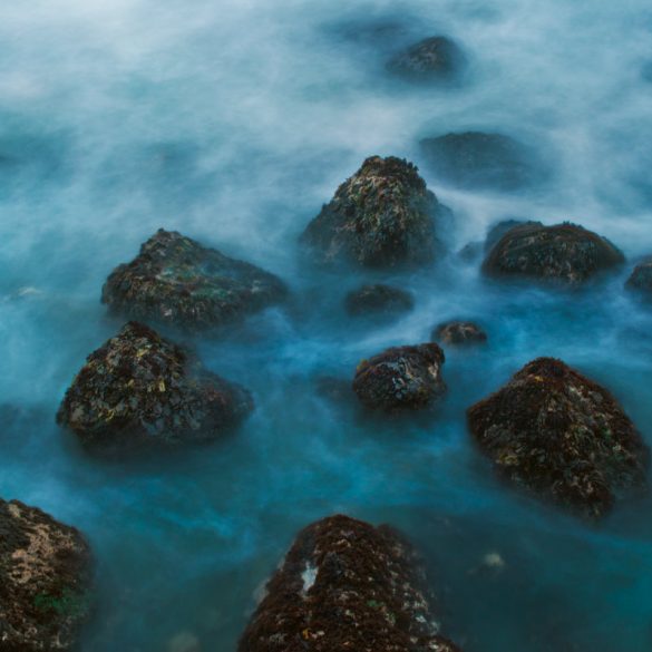 A long exposure photo of a rocky seashore on the California coast