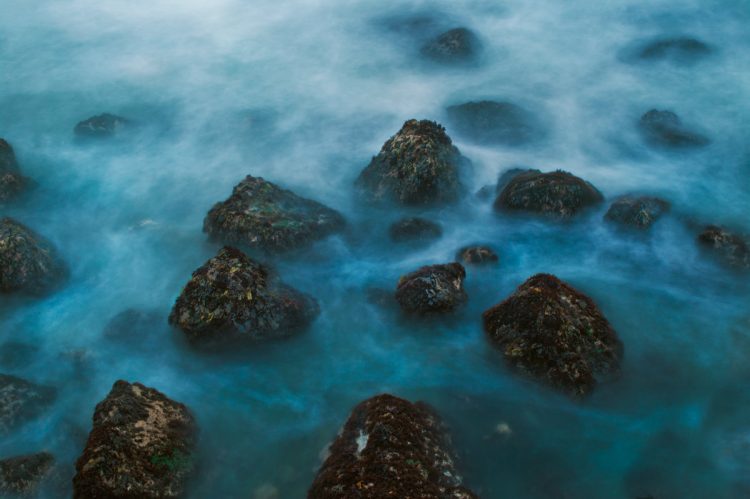 A long exposure photo of a rocky seashore on the California coast