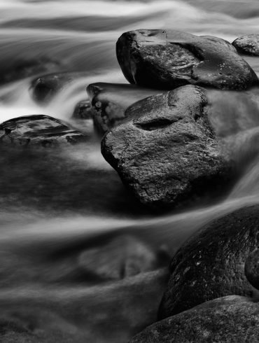 A long exposure photography shot of rocks in a river in Great Smoky Mountains National Park