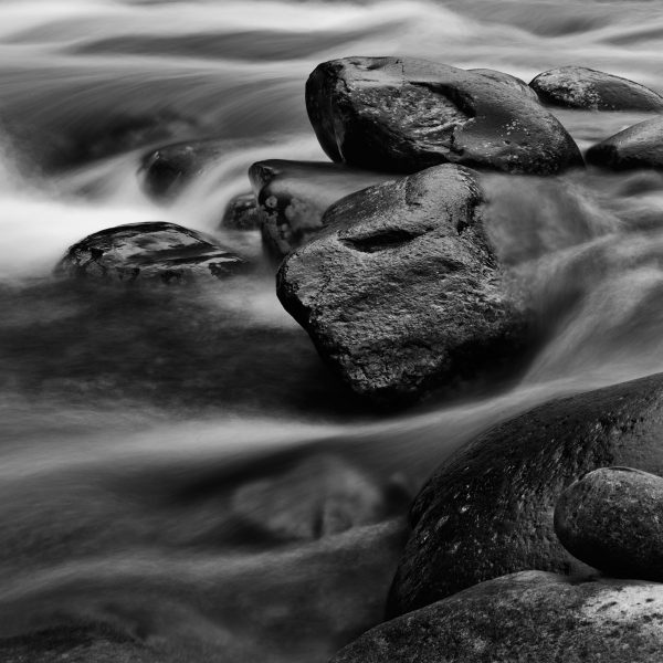 A long exposure photography shot of rocks in a river in Great Smoky Mountains National Park