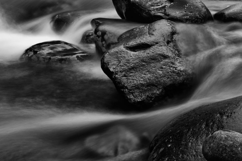 A long exposure photography shot of rocks in a river in Great Smoky Mountains National Park